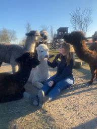 Michéle von Holten zwischen den Alpakas im Tierpark